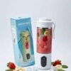 Portable Multi-purpose Blender (Juicing Cup) filled with fruit and ice, next to its retail box.